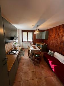 a kitchen and living room with a table and a couch at Apartment surrounded by the peace of nature in Torgnon