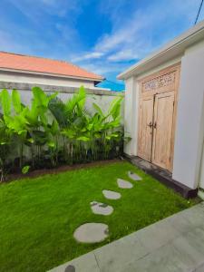 a yard with stepping stones in front of a house at Casagana by Gana Management Canggu in Dalung