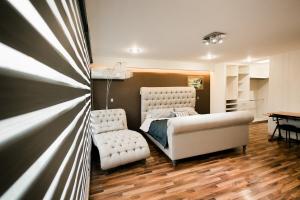 - une chambre avec un lit et deux chaises blanches dans l'établissement Residencia privada en León, à Cañada