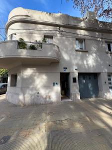 a white building with a balcony on the side of it at Ideal Centro Junin in Junín