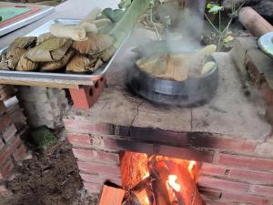 a person cooking food in a pot over a fire at Red Clay Pension Dream Conversation in Donghae