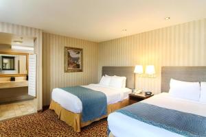 a hotel room with two beds and a bathroom at Laguna Brisas - A Beach Hotel in Laguna Beach +33 photos