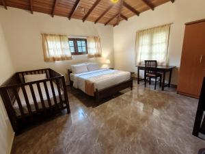 a bedroom with a bed and a table and a desk at Watawala Tea Garden in Rozella +3 photos