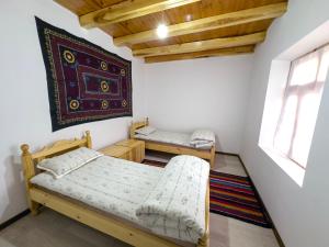 a bedroom with two bunk beds and a window at Nur Homestay in Nurata Mountains in Yukary-Ukhum