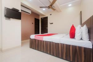 um quarto com uma cama com almofadas vermelhas e brancas em Hotel O Shalimar em Mumbai