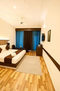 a bedroom with a king sized bed and blue curtains at The Kasauli woods in Kasauli +4 photos