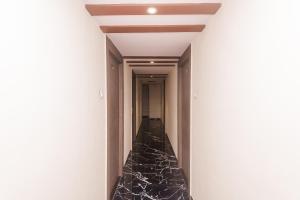 a hallway with black marble floors and a ceiling at Hotel O Shalimar in Mumbai