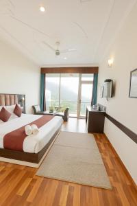 a bedroom with a large bed and a large window at The Kasauli woods in Kasauli