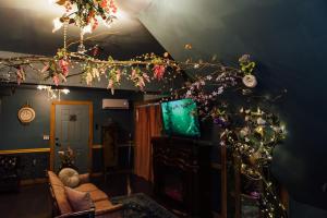 a living room with a tv and a tree with flowers at Escape to Villa Serena in Dahlonega