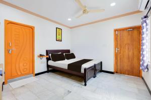 a bedroom with a bed and a wooden door at Super Hotel O Guntur Railway Junction in Guntūr