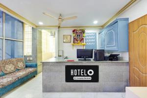 a hotel lobby with a reception desk and a couch at Super Hotel O Guntur Railway Junction in Guntūr