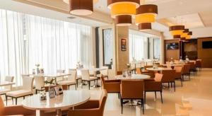 a restaurant with white tables and chairs and windows at Jinjiang Inn Select Hohhot Chengjisihan Square Metro Station in Hohhot