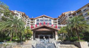 een gebouw met palmbomen ervoor bij Fu'an Tailong Sea-view Hotel (Danzhou Haihua Island) in Dongshan