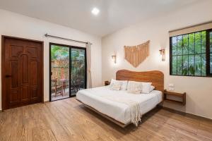 a bedroom with a bed and a large window at Casa Wayra Tulum - Boutique Condos in Tulum
