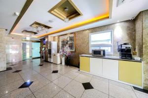 a lobby of a building with a counter and a kitchen at Yeosu Apple Hotel in Musŏn