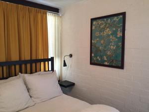 a bedroom with a bed and a painting on the wall at Vakantiehuis in Stavenisse +23 photos