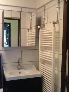 a white bathroom with a sink and a mirror at Vakantiehuis in Stavenisse