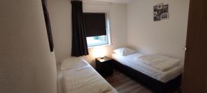 two beds in a small room with a window at Stuivezandeweg 6 in Callantsoog