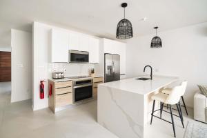 a kitchen with white cabinets and a counter top at Walk to Beach New Stylish 3BR Pool in Saint James