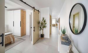 a hallway with a mirror on the wall and a chair at Walk to Beach New Stylish 3BR Pool in Saint James