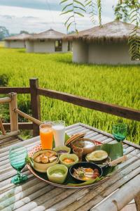 a tray of food sitting on a table with drinks at Na Bua Villa Chiangrai in Ban Rim Lao +15 photos