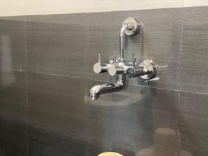 a bathroom sink with a faucet on a wall at De Luxury Villa in Pūrnānkuppam +44 photos