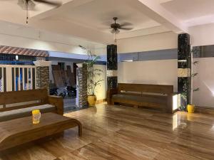 a lobby with benches and plants in a room at De Luxury Villa in Pūrnānkuppam