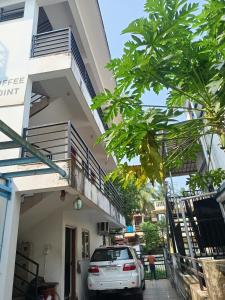 ChicalimGuest House Sai Leela的一辆白色汽车停在一栋建筑物前