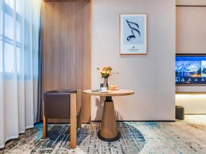 a table and a chair in a room at Mousse Hotel Liyang Railway Station Museum Branch 