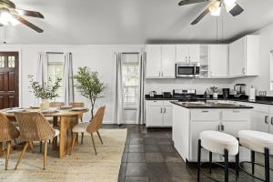 a kitchen with white cabinets and a table and chairs at Central East Austin Luxury Hot Tub & Game Room in Austin