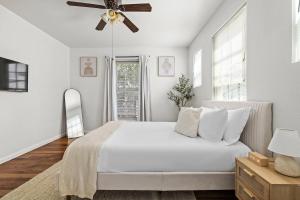 a white bedroom with a bed and a ceiling fan at Central East Austin Luxury Hot Tub & Game Room in Austin +65 photos