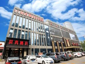 een groot gebouw met auto's ervoor geparkeerd bij Shell Hotel Tai'an Feicheng Longshan Road in Muzhuang