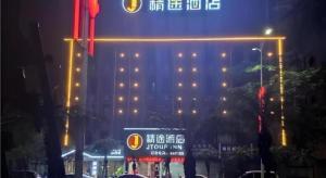 a hotel with a sign in front of it at night at JTOUR Inn Zhanjiang Poly Yuandian Plaza in Zhanjiang