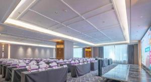 長沙市にあるEcharm Hotel Changsha Wuyi Square Railway Metro Stationの部屋の中にテーブルと椅子が置かれた宴会場