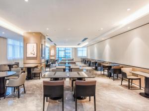a restaurant with tables and chairs and a chalkboard at Mousse Hotel Liyang Railway Station Museum Branch 