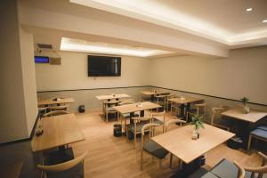 大同市にあるGreenTree Inn Express Datong High-Speed Railway Station Old City Wallのテーブルと椅子、薄型テレビのあるレストラン