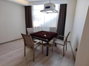 a dining room table and chairs in a room with a window at GreenTree Inn Express Fuzhou Linchuan District Gandong Auto City in Shiliting