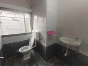 um banheiro com vaso sanitário e pia em Hotel O Sai Shlok Inn Lodging em Nashik