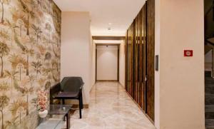 a hallway with a chair and a table in a building at Collection O A&M Regency, WEBLE More in Thākurdwari