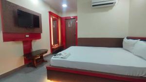 a hotel room with a bed and a tv at Collection O A&M Regency, WEBLE More in Thākurdwari +7 photos