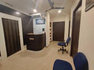 a room with a desk and a blue chair at Collection O A&M Regency, WEBLE More in Thākurdwari
