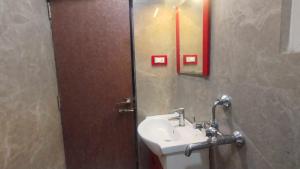 a bathroom with a sink and a mirror at Collection O A&M Regency, WEBLE More in Thākurdwari