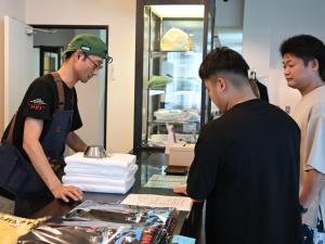 three men standing around a table with a cake at 千丈温泉 ペンシオーネセイモア サウナはくさん SENJO Onsen PENSIONE SEYMOUR Sauna Hakusan in Hakusan