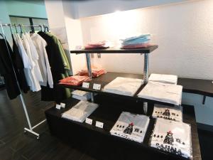 a clothing store display with shirts and clothes on racks at 千丈温泉 ペンシオーネセイモア サウナはくさん SENJO Onsen PENSIONE SEYMOUR Sauna Hakusan in Hakusan +66 photos