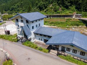 an overhead view of a building with a blue roof at 千丈温泉 ペンシオーネセイモア サウナはくさん SENJO Onsen PENSIONE SEYMOUR Sauna Hakusan in Hakusan