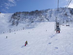 a group of people riding a ski lift on a snow covered slope at 千丈温泉 ペンシオーネセイモア サウナはくさん SENJO Onsen PENSIONE SEYMOUR Sauna Hakusan in Hakusan