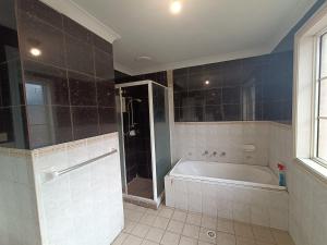 a large bathroom with a tub and a shower at Budget Queen Room - 492 in Wentworthville