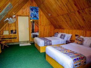 1 Schlafzimmer mit 2 Betten in einer Holzhütte in der Unterkunft Ankara Garden Resort Nairobi in Ongata Rongai 