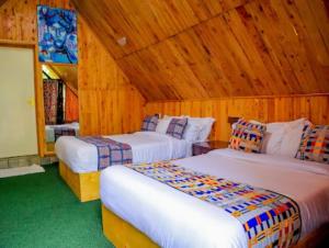 zwei Betten in einem Zimmer mit Holzwänden in der Unterkunft Ankara Garden Resort Nairobi in Ongata Rongai 