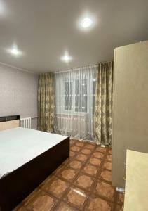 a bedroom with a large bed and a window at Хромтау in Khromtaū